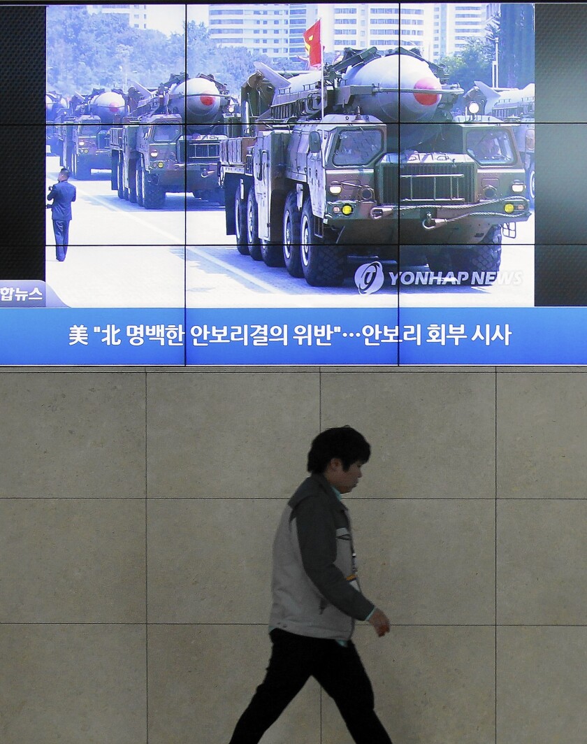 A giant screen in Seoul shows file footage of North Korean missiles in a military parade on a TV news program. North Korea test-launched two medium-range ballistic missiles Wednesday.