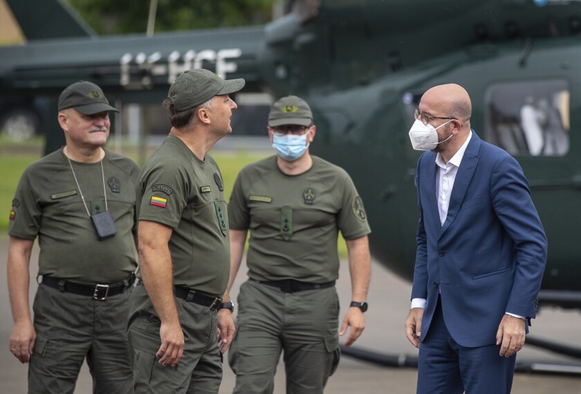 European Council President Charles Michel, right, speaks with members of the Lithuania State Border Guard as he arrives at the Border Guard School near Lithuanian-Belarusian border, near the village Medininkai, some 25 km (24 miles) east of the capital Vilnius, Lithuania, Tuesday, July 6, 2021. (AP Photo/Mindaugas Kulbis)
