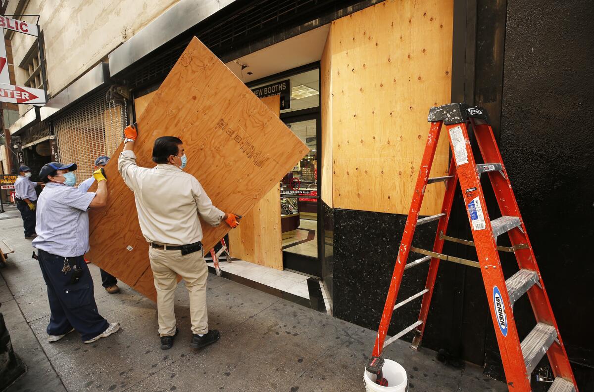 Workmen build a plywood wall at the storefront of a complex of jewelry stores in downtown L.A. ahead of election day.
