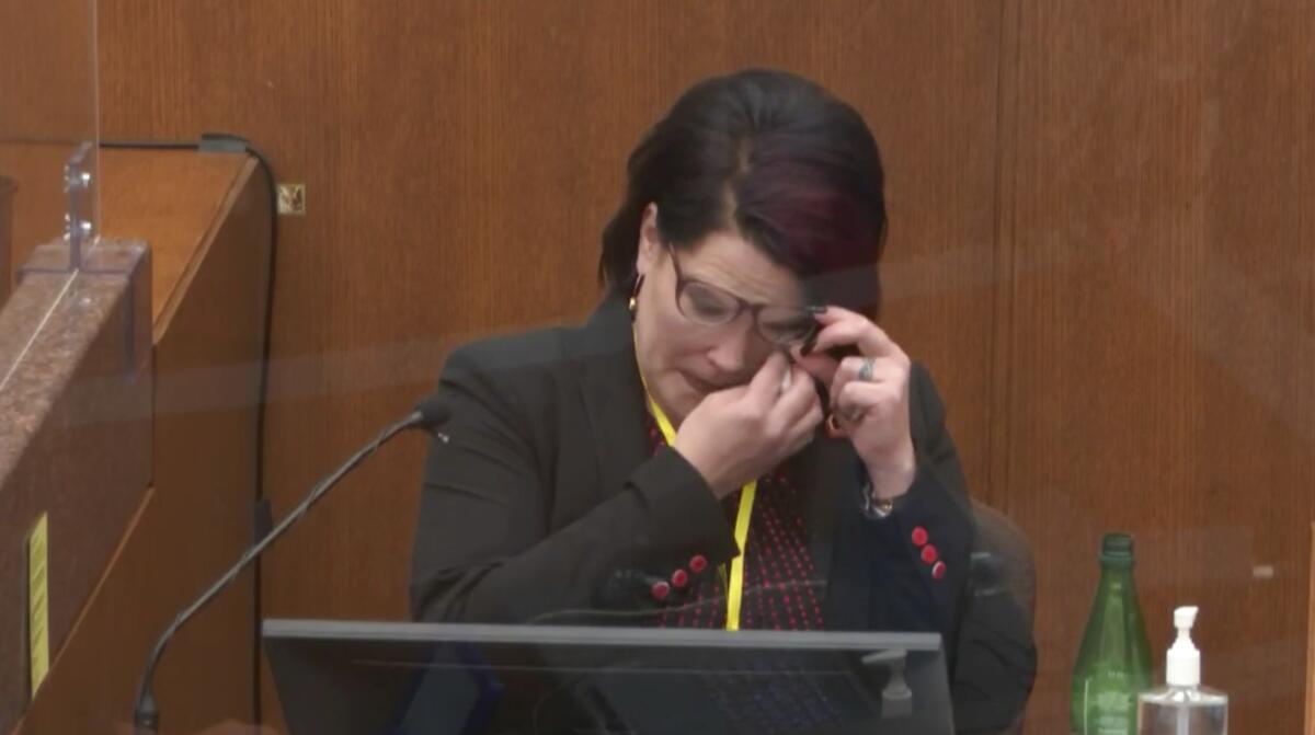 Courteney Ross wipes her eyes on the witness stand.