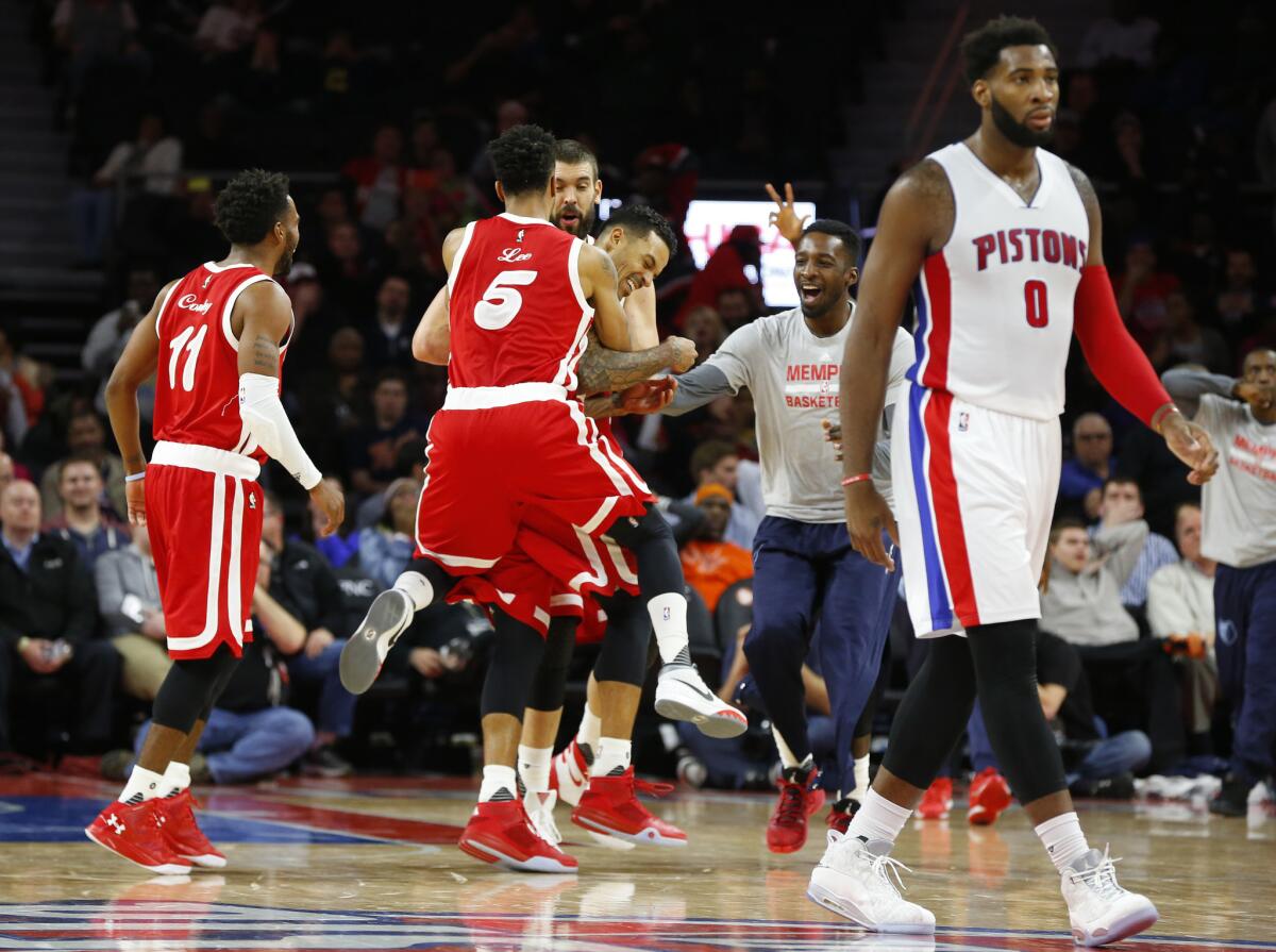 Grizzlies forward Matt Barnes, middle, is mobbed by his teammates after hitting a game-winning three point shot from half court against the Pistons.