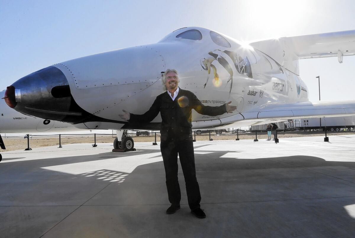 British entrepreneur Richard Branson poses with SpaceShipTwo at Virgin Galactic 's hangar in Mojave, Calif., in 2013. Virgin will now test its new SpaceShipTwo rocket without Scaled Composites, its longtime aerospace partner that designed and built the first plane.