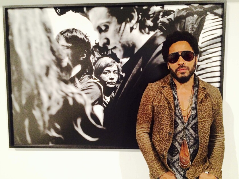 FILE - In this image taken from video, Musician Lenny Kravitz stands in front of one of his photos from his exhibit "Flash", which is running in conjunction with Art Basel in Miami Beach, Wednesday, Dec. 2, 2015. Kravitz gave a private performance, Friday, Dec. 3, 2021, for a star-studded crowd that included Leonardo DiCaprio and local Latin boy band CNCO during Miami’s Art week. (AP Photo/Joshua Replogle, File)