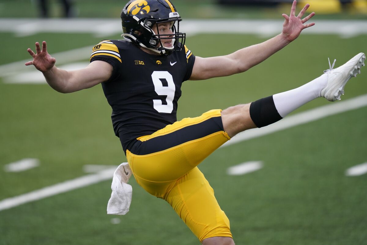 FILE - Iowa punter Tory Taylor punts during the second half of an NCAA college football game against Northwestern in Iowa City, Iowa, in this Saturday, Oct. 31, 2020, file photo. Tory Taylor sells T-shirts that say "Punting Is Winning." Those words describe what's going on at No. 2 Iowa, where Taylor's punting has played a huge factor in the Hawkeyes' 6-0 start. (AP Photo/Charlie Neibergall, File)