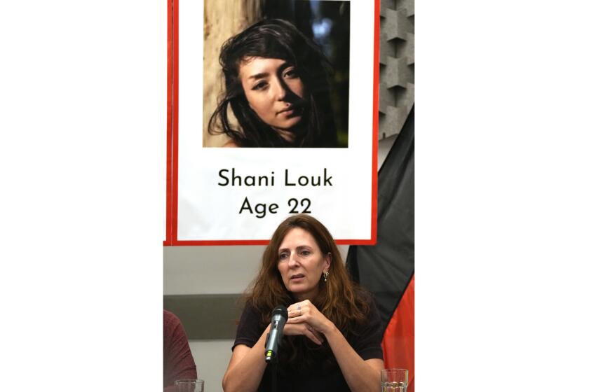 ARCHIVO - Ricarda Louk se mantiene sentada el martes 17 de octubre de 2023 en Tel Aviv frente a un cartel con la imagen de su hija Shani Louk, que fue tomada como rehén por el grupo miliciano Hamás en una incursión a territorio israelí el 7 de octubre. (AP Foto/Maya Alleruzzo, archivo)