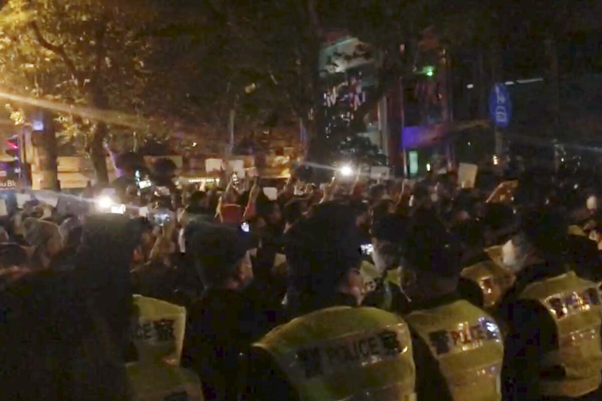 Imagen de un video obtenida por The Associated Press de la policía viendo a manifestantes en Shanghái el sábado, 26 de noviembre de 2022. (AP Foto)
