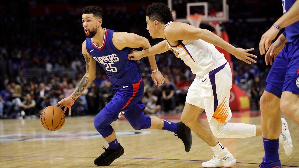 The Clippers' Austin Rivers drives past Phoenix Suns' Devin Booker during Sunday's game.