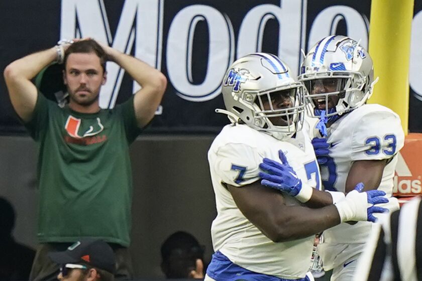 Middle Tennessee defensive tackle Zaylin Wood (7) celebrates with cornerback Decorian Patterson (33) after Wood intercepted the ball and scored during the first half of an NCAA college football game against Miami, Saturday, Sept. 24, 2022, in Miami Gardens, Fla. (AP Photo/Wilfredo Lee)