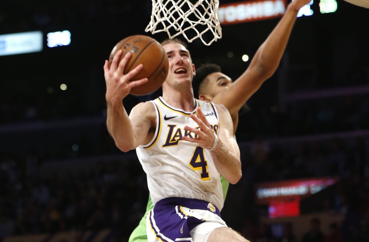 Lakers guard Alex Caruso puts up a shot in front of Minnesota Timberwolves center Karl-Anthony Towns.