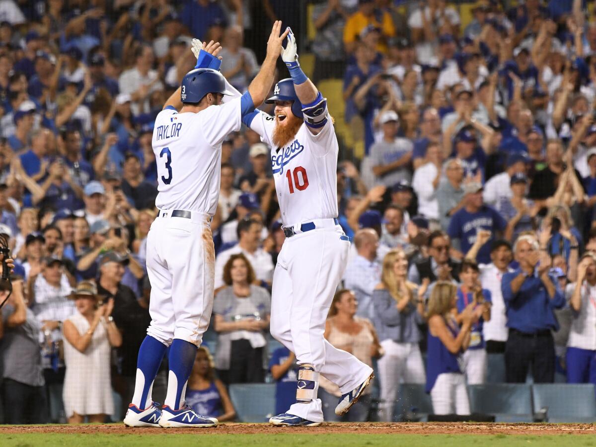 The Dodgers' Chris Taylor, left, congratulates Justin Turner, who hit a two-run home run against the Houston Astros in Game 1 of the World Series.