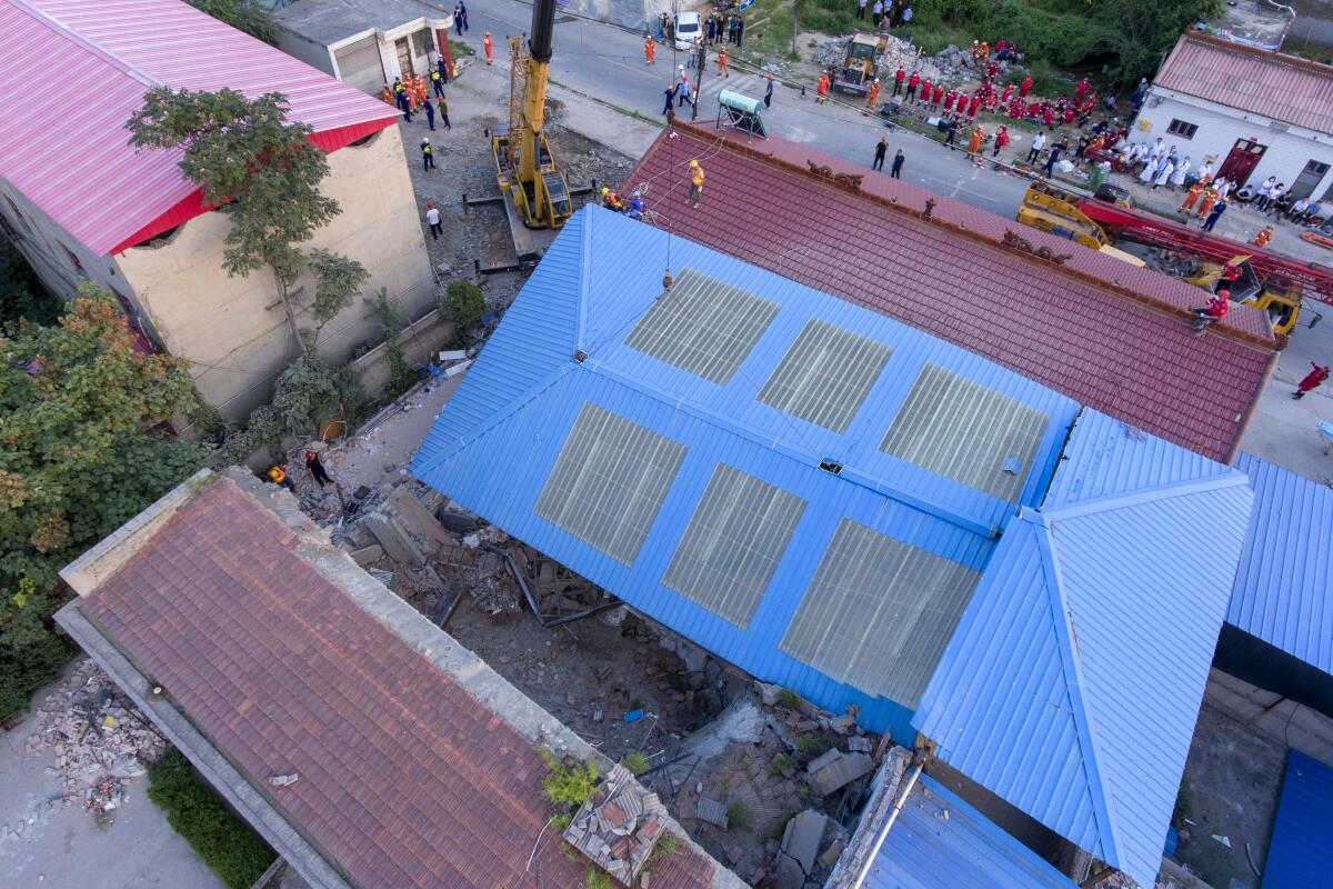 Rescuers work at the site of a collapsed two-story restaurant in a northern Chinese village.