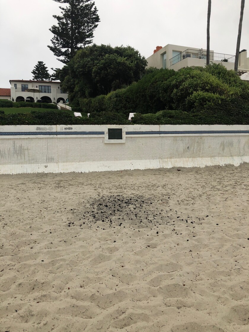 Remnants from a fire at Marine Street Beach in La Jolla are scattered in the sand.