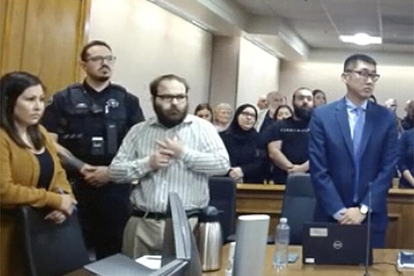 In this image taken from video provided by the Colorado Judicial Branch, Ahmad Alissa, third from left, stands for the verdict in his trial for the 2021 Colorado supermarket shootings, Monday, Sept 23, 2024, in Boulder, Colo. (Colorado Judicial Branch via AP)