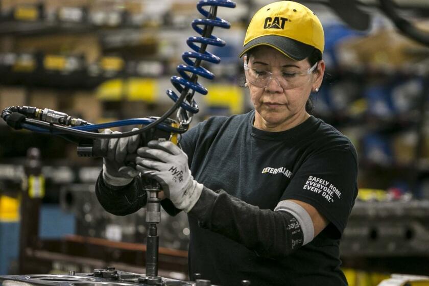 In this June 13, 2018, photo, Margarita Cardenas attaches an engine head at Caterpillar's engine manufacturing plant in Seguin, Texas. Caterpillar is part of a broader heavy machinery and equipment manufacturing industry in Texas that employs about 90,000 people and shipped more than $40 billion in industrial machinery to international buyers last year, making it the state's second leading export after petroleum and accounting for 16 percent of all Texas exports. (Josie Norris/The San Antonio Express-News via AP)