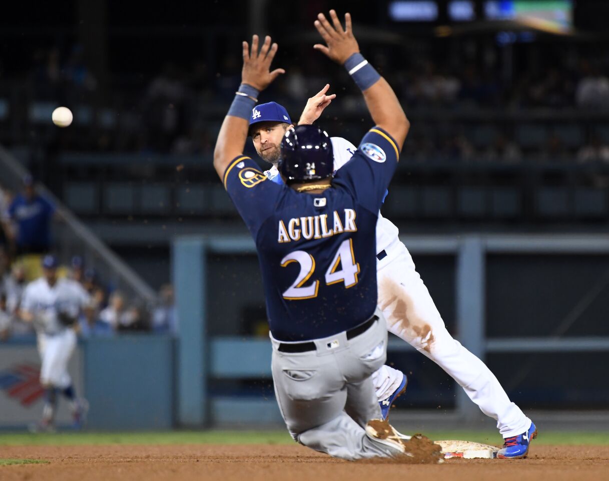 Dodgers 2nd baseman Brian Dozier completes the double play in front of Brewers base runner Jesus Aguilar in the 4th inning.