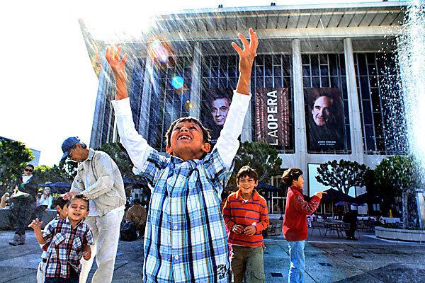 Children attending LA Opera's open house Saturday have fun at the fountain outside the Dorothy Chandler Pavilion. The free daylong event to celebrate the opera's 25th anniversary included a performance by Placido Domingo and James Conlon.
