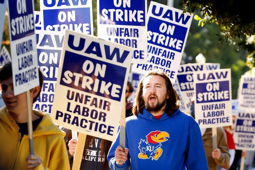 LOS ANGELES-CA - NOVEMBER 14, 2022: Trevor Scheopner, a grad student researcher, center, joins a demonstration at UCLA as nearly 48,000 University of California academic workers strike on Monday, November 14, 2022, in a labor action that could shut down some classes and lab work just weeks before final exams. Scheopner says that more than two thirds of his income goes toward his rent and with the cost of living in Los Angeles and rapid inflation, it's getting tougher. (Christina House / Los Angeles Times)
