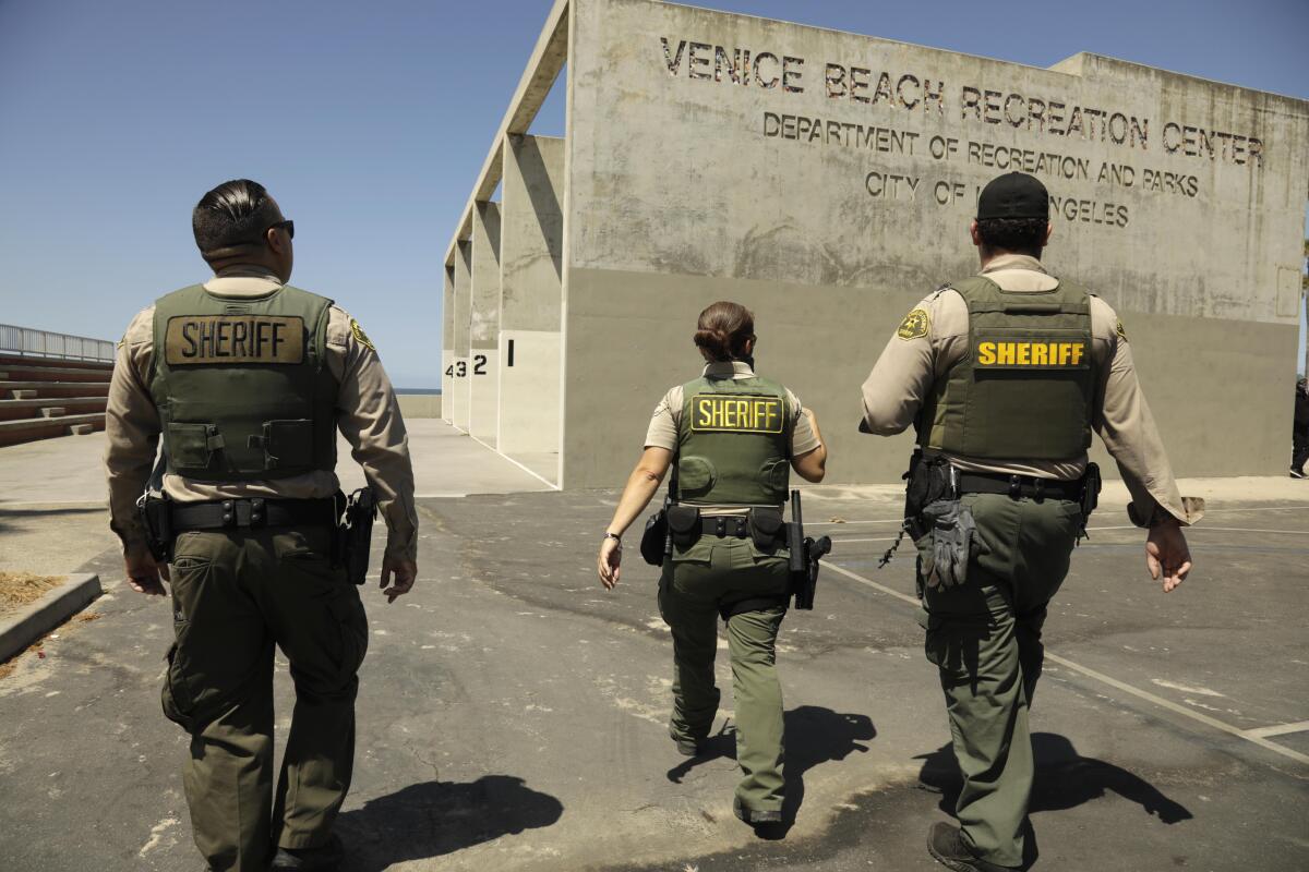Three sheriff's deputies walk in front of the Venice Beach Recreation Center