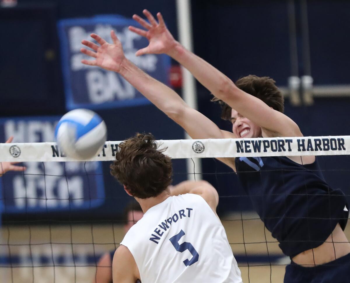 Sterling Foley (11) of Corona del Mar blocks a kill attempt by Newport Harbor's Riggs Guy (5) on Wednesday.