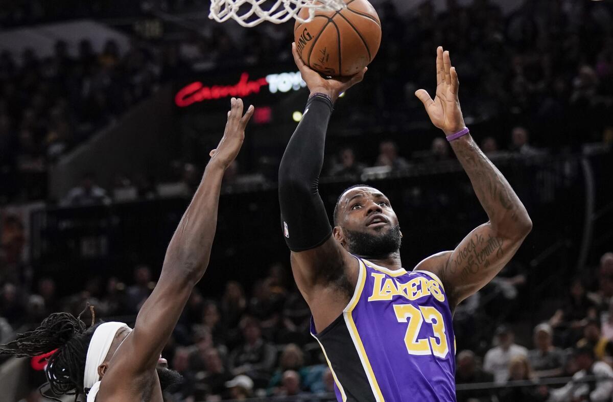 Lakers star LeBron James shoots over Spurs forward DeMarre Carroll.