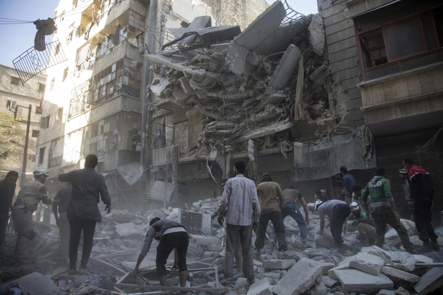 Syrian civilians gather after government airstrikes in the rebel-held Shaar neighborhood of Aleppo.