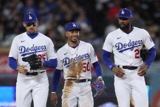 Los Angeles Dodgers second baseman Mookie Betts, center, walks back to the dugout with right fielder Jason Heyward.