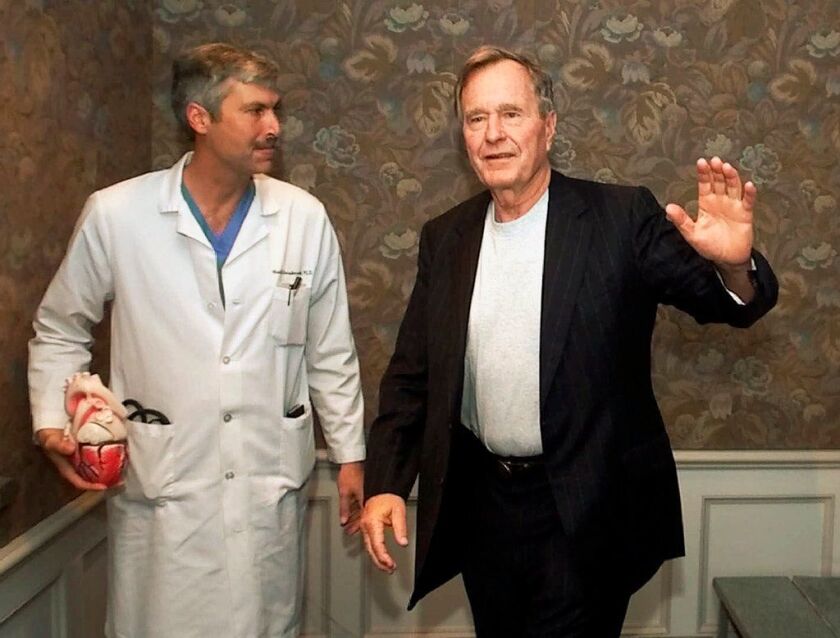 Former President George H.W. Bush waves as he leaves Methodist Hospital with his cardiologist, Mark Hausknecht, in 2000. Hausknecht was fatally shot by a fellow bicyclist Friday, July 20, 2018, while riding through a Houston medical complex.