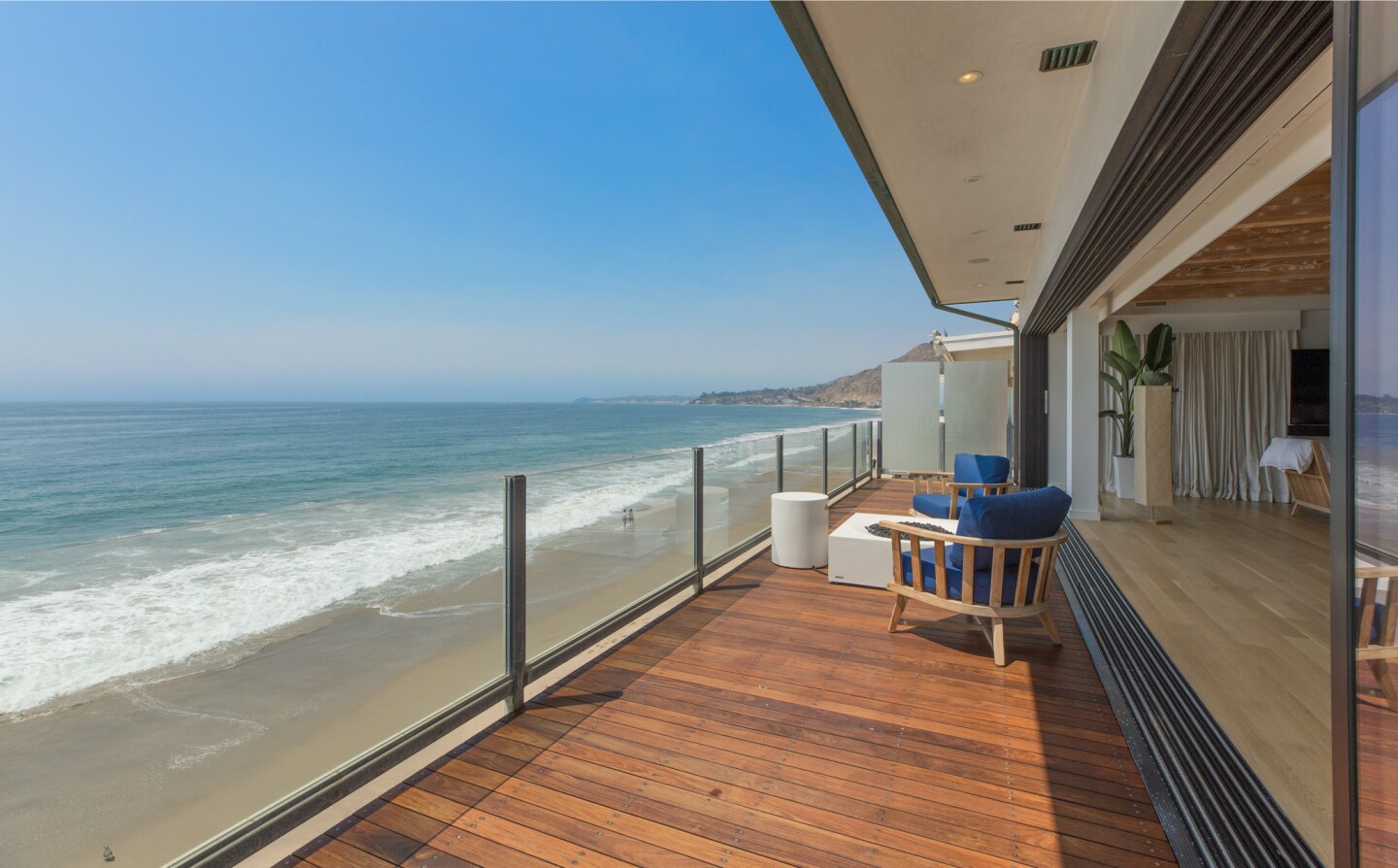 The architectural beach house expands to two levels of wood decks overlooking the ocean.