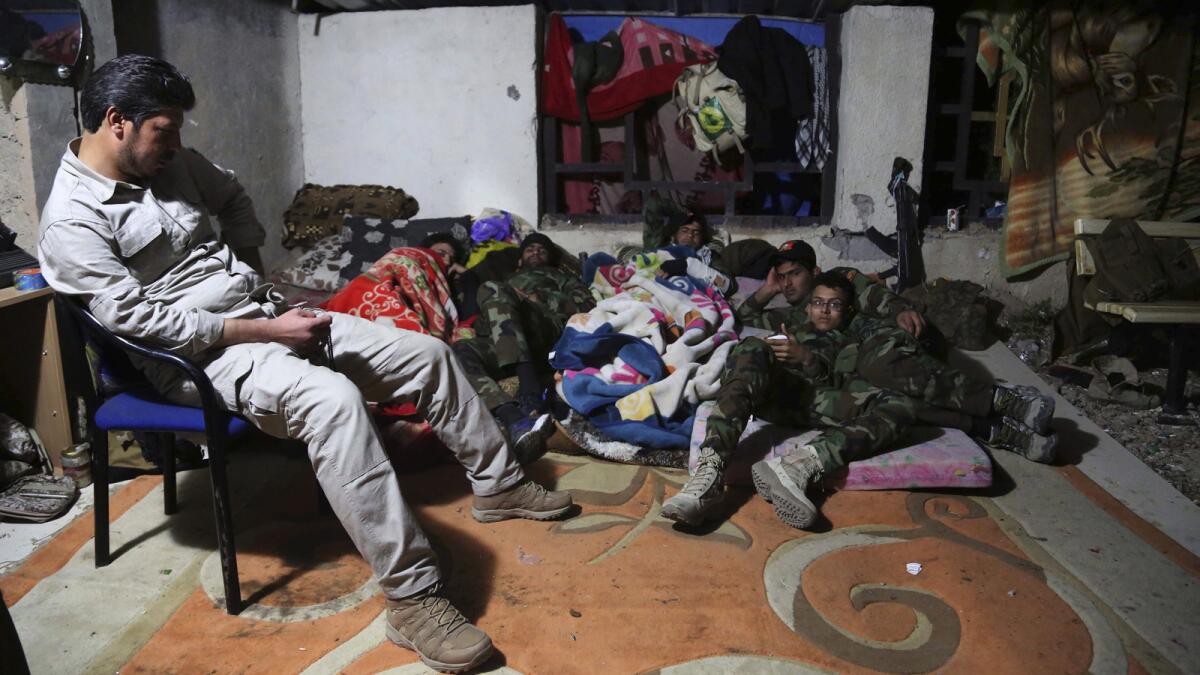 Shiite militiamen rest in Tikrit, Iraq, where the United States began airstrikes Wednesday.