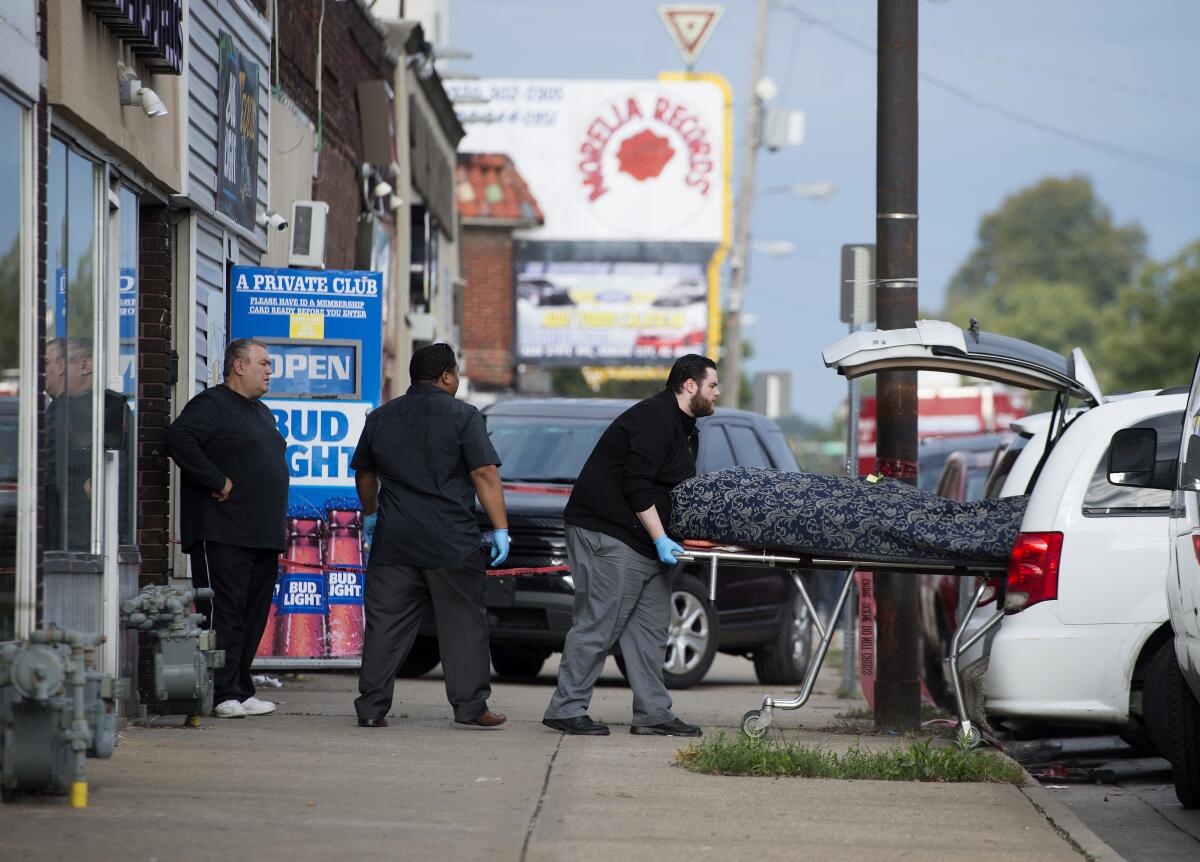 The body of a shooting victim is placed in a coroner's van Sunday outside Tequila KC Bar.