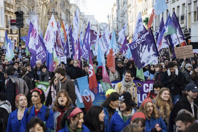 Protestors wave flags during a rally, called by left-wing La France Insoumise (LFI) party and Youth organizations, to protest against the French President's pension reform, in Paris, Saturday, Jan. 21, 2023. (AP Photo/Lewis Joly)