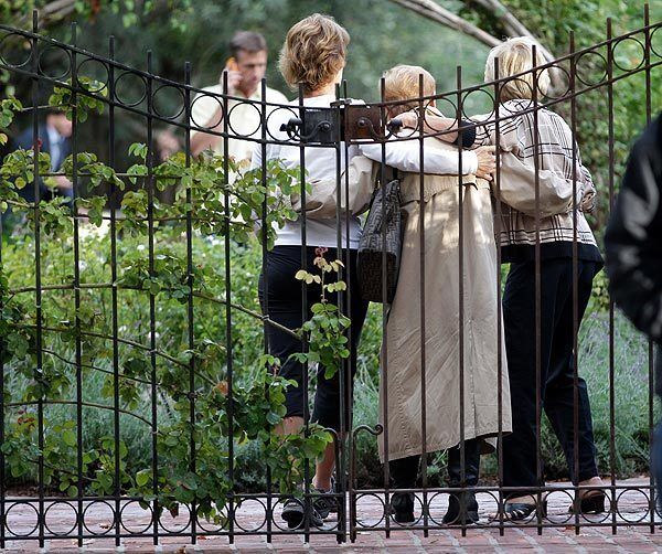 Unidentified women embrace before they enter Steve Jobs' house in Palo Alto, Calif., Wednesday. Jobs, the Apple co-founder and former CEO invented and masterfully marketed ever-sleeker gadgets that transformed everyday technology.