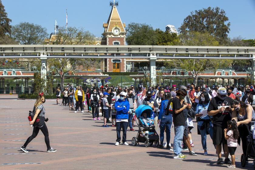 ANAHEIM, CA - March 18: With a view of Disneyland behind them, Disney fans wait in line to attend the debut of Disney California Adventure's "A Touch of Disney."