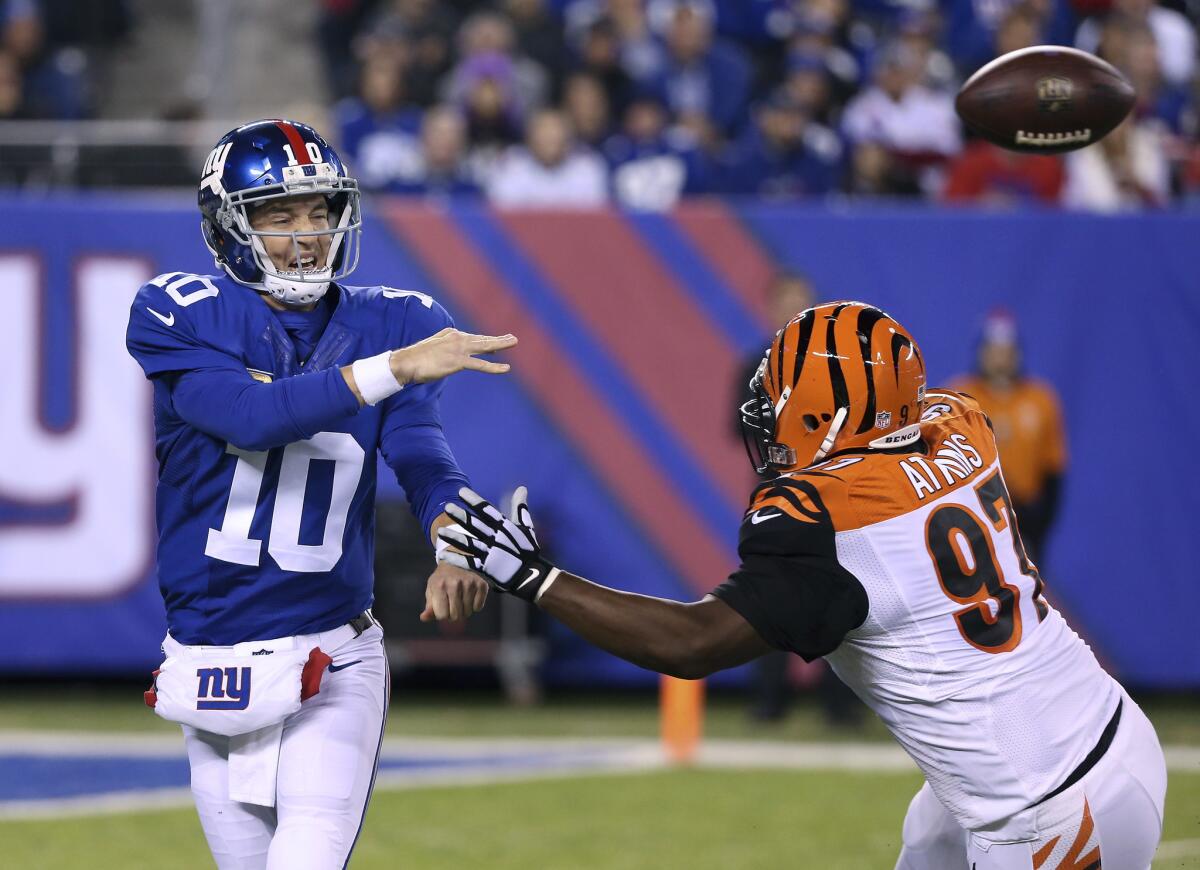 New York Giants quarterback Eli Manning (10) throws under pressure from Cincinnati Bengals defensive tackle Geno Atkins (97) during the second quarter of an NFL football game, Monday, Nov. 14, 2016, in East Rutherford, N.J. (AP Photo/Seth Wenig)