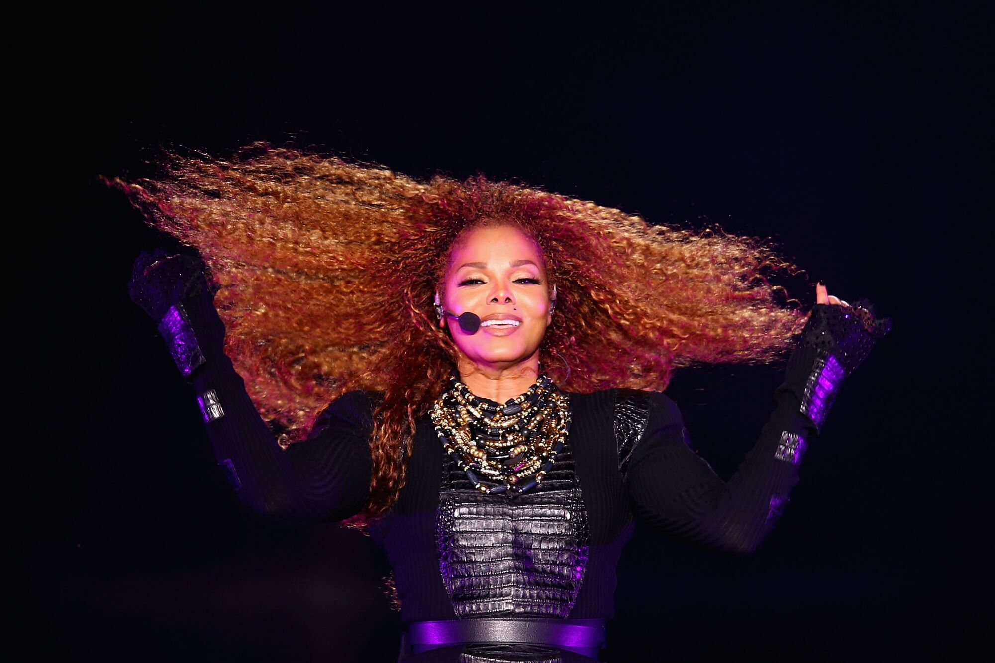 A woman with long red hair performs onstage