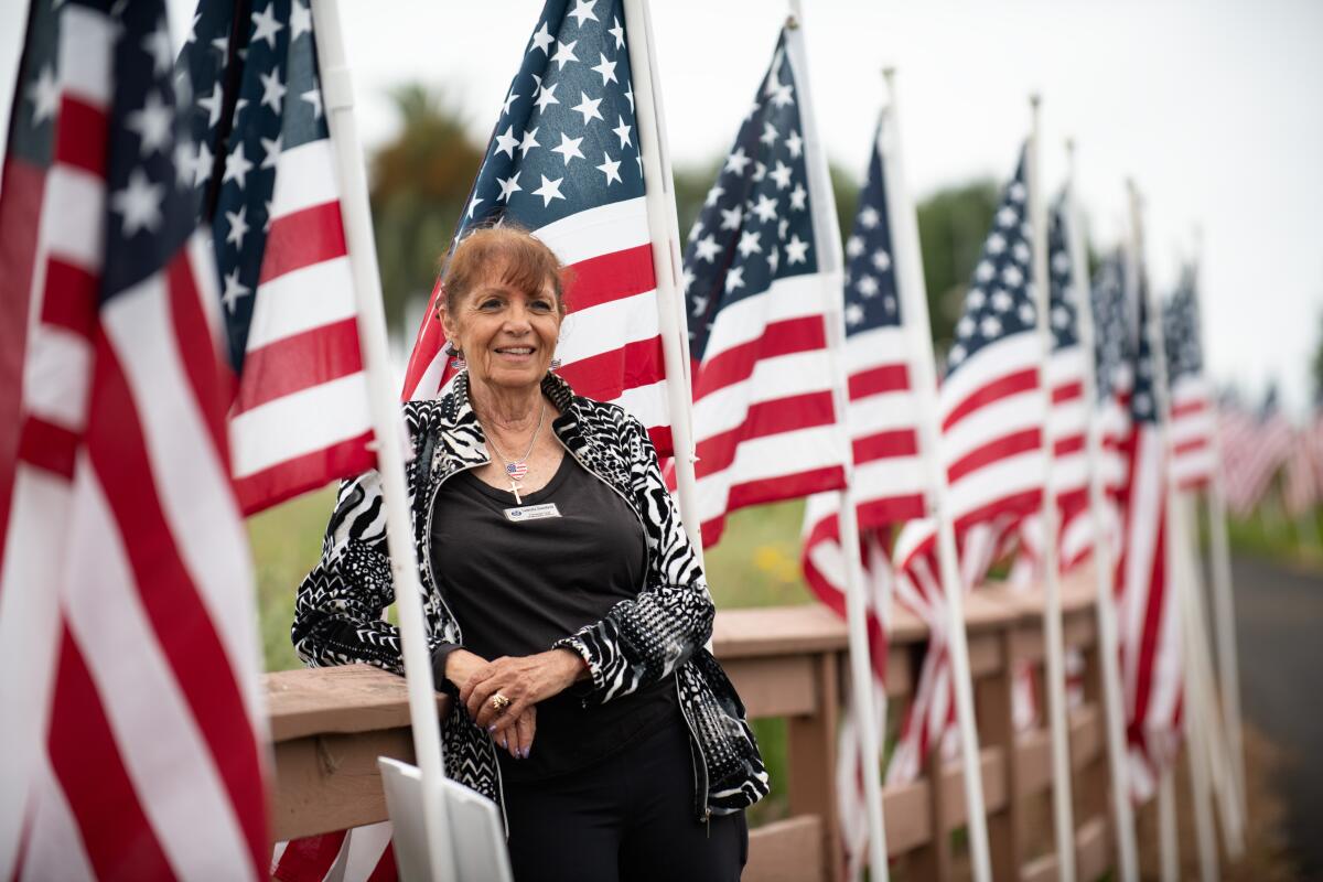 Lauretta Stansfield of the Exchange Club of Newport Beach with flags at Castaways Park.