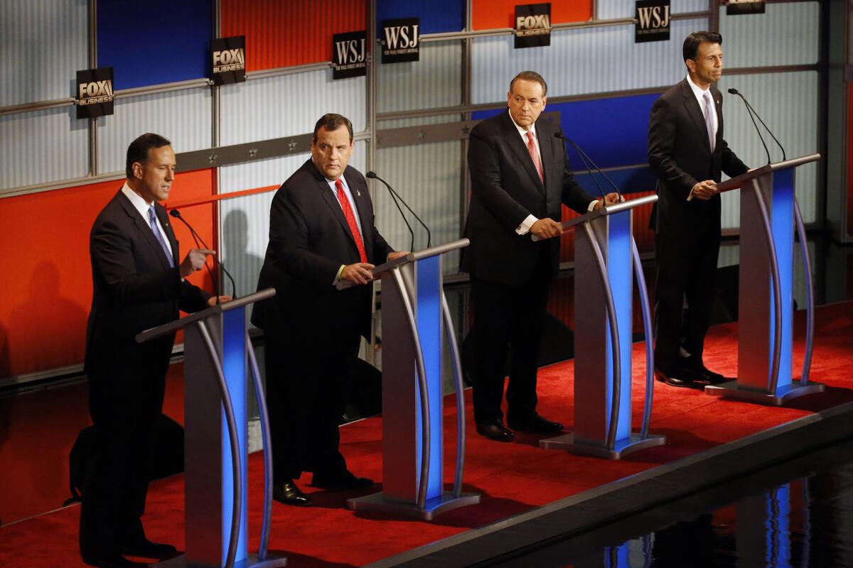 Rick Santorum, left, speaks as Chris Christie, Mike Huckabee and Bobby Jindal listen during the Republican presidential debate for lower-polling candidates Tuesday in Milwaukee.