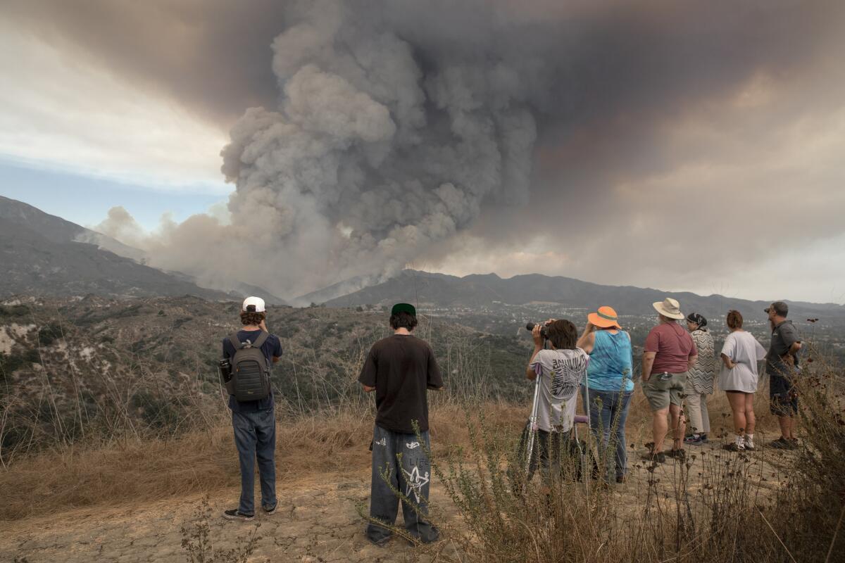 People watch the rapidly growing Airport fire burning in Trabuco Canyon.