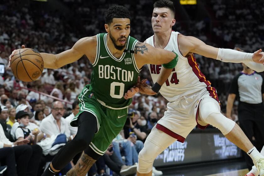 Boston Celtics forward Jayson Tatum (0) dribbles the ball as Miami Heat guard Tyler Herro (14) defends during the first half of Game 2 of the NBA basketball Eastern Conference finals playoff series, Thursday, May 19, 2022, in Miami. (AP Photo/Lynne Sladky)