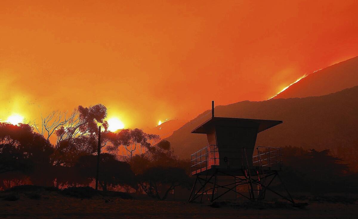 A lifeguard tower stands near the Pacific Coast Highway as flames from the Springs fire head toward the ocean near Sycamore Canyon in May 2013.