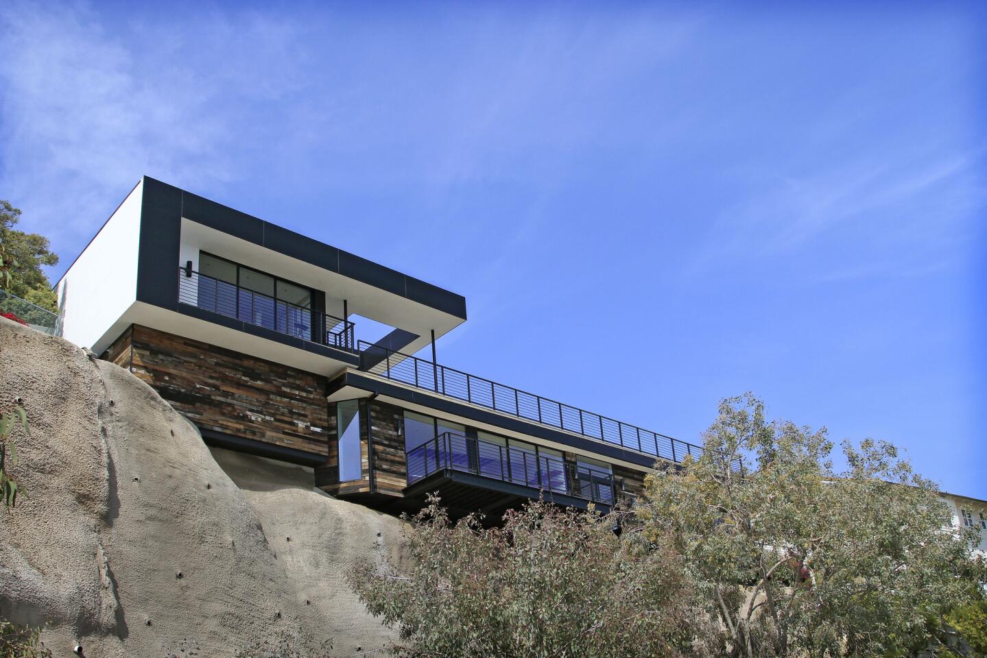As seen from Malibu's Broad Beach, the house rises as a streamlined structure set atop a rustic base — "a juxtaposition between hard lines and soft lines," W+D founding partner Brett Woods says. "Pure geometry coming off this rugged hillside."