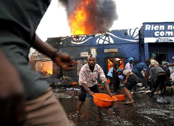 A bucket brigade delivers water to shops set ablaze by the crash of a jet in Goma, Congo. There were six survivors of the crash, including the pilot and co-pilot, said an official in the control tower in Kinshasa.