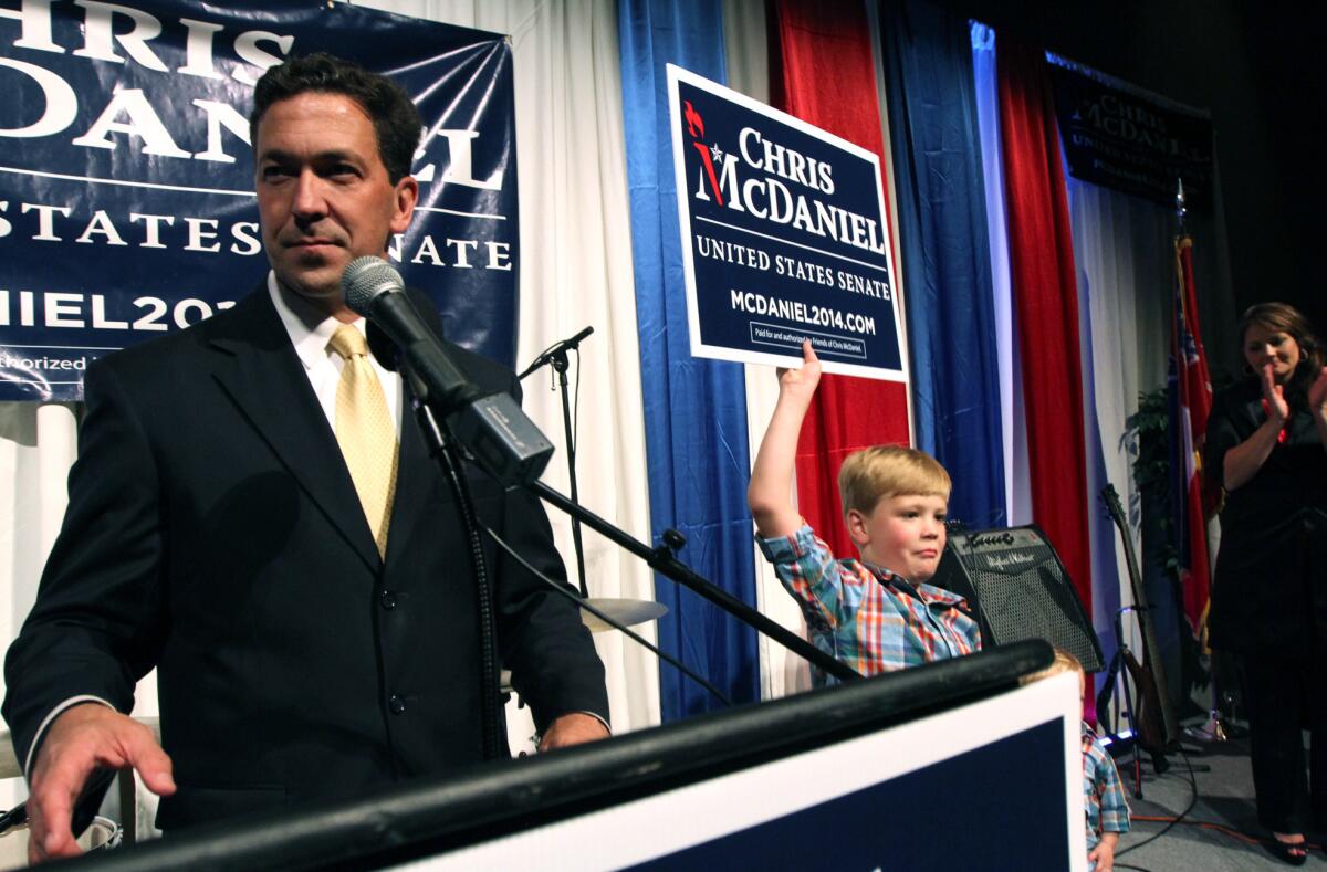 Chris McDaniel addresses his supporters as his son Cambridge, 7, joins him on the stage at the Lake Terrace Convention Center in Hattiesburg, Miss.