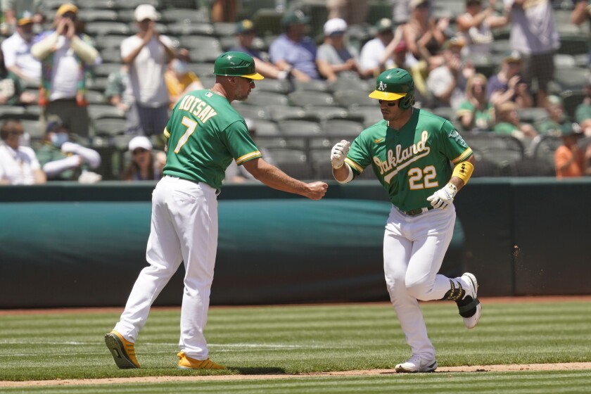 Oakland Athletics' Ramon Laureano is greeted by third base coach Mark Kotsay after hitting a home run in the fourth inning of a baseball game Wednesday, June 16, 2021, in Oakland, Calif. (AP Photo/Eric Risberg)