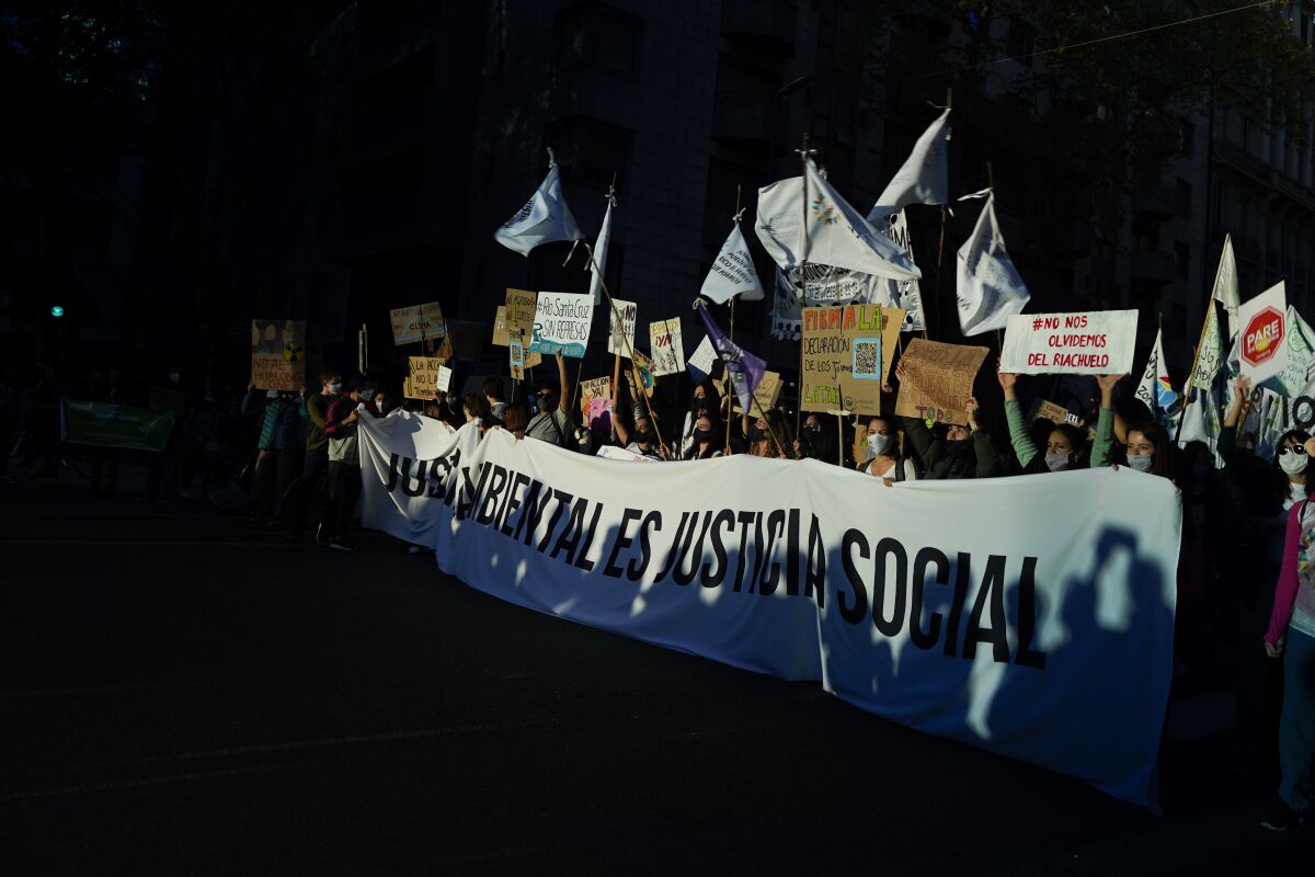 FILE - People march holding a banner with a message that reads in Spanish; "Environmental justice is social justice" during a global climate strike demonstration in Buenos Aires, Argentina, Sept. 24, 2021. Philanthropy can fight climate change more effectively if more donors focus on funding climate justice issues and battling inequality, according to a report from the philanthropy research organization Candid released Wednesday, June 8, 2022. According to the report, only about 2% of global giving goes to climate change mitigation and less than 4% of that – about $60 million in 2019 – is designated for climate justice and equity-oriented work. (AP Photo/Victor R. Caivano, file)