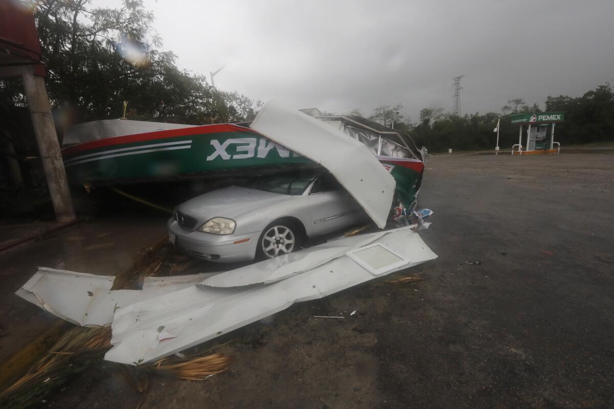 A car is crushed under a metallic structure amid Hurricane Grace in Playa del Carmen, Mexico.