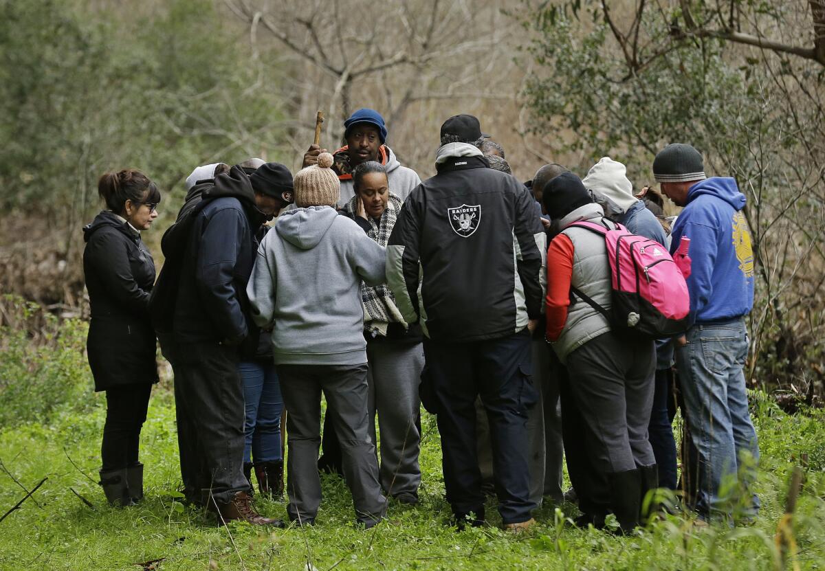 Family members and friends gather Monday near the banks of Alameda Creek where the vehicle of a missing 18-year-old woman was believed to be located.