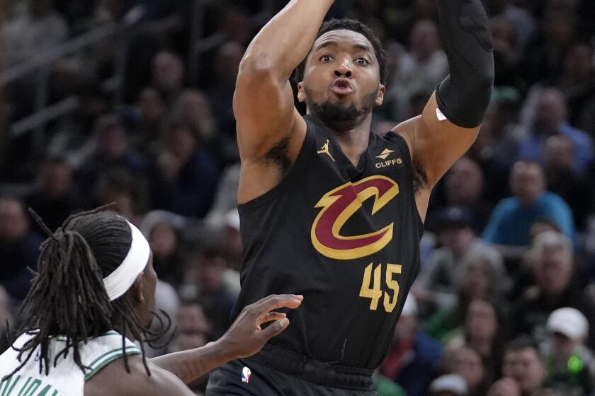 Cleveland Cavaliers guard Donovan Mitchell (45) shoots next to Boston Celtics guard Jrue Holiday (4) during the second half of Game 2 of an NBA basketball second-round playoff series Thursday, May 9, 2024, in Boston. (AP Photo/Steven Senne)