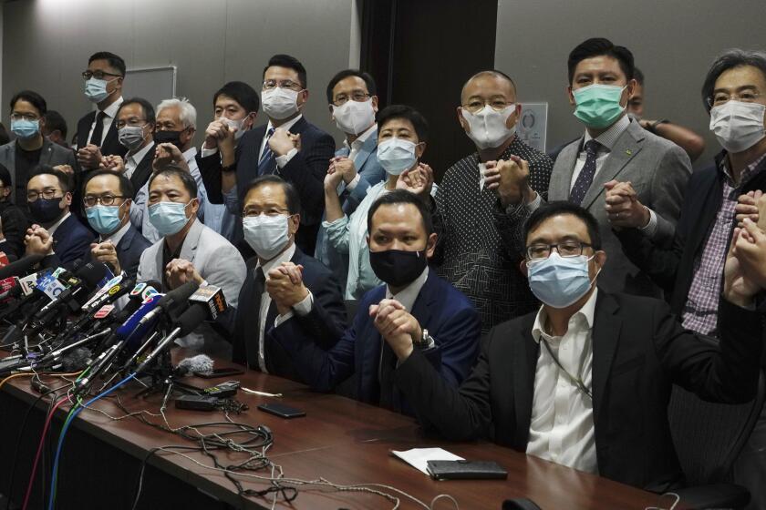 Hong Kong's pro-democracy legislators pose for a photo before a press conference at Legislative Council in Hong Kong, Wednesday, Nov. 11, 2020. Hong Kong's pro-democracy lawmakers announced that they are resigning en masse following a move by the city's government to disqualify four pro-democracy legislators. (AP Photo/Vincent Yu)