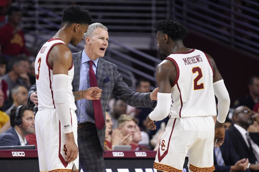 Southern California head coach Andy Enfield, center, speaks with Jonah Mathews, right, and Elijah Weaver during the second half of an NCAA college basketball game against Stanford in Los Angeles, Saturday, Jan. 18, 2020. Southern California won 82-78. (AP Photo/Kelvin Kuo)